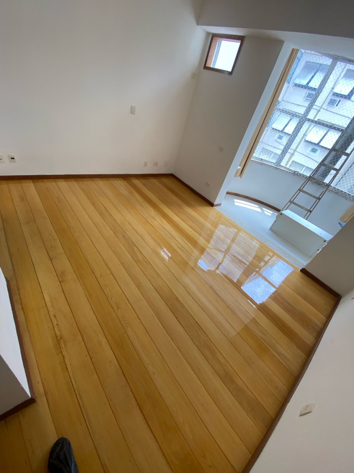 Quarto com piso de madeira clara e acabamento espelhado